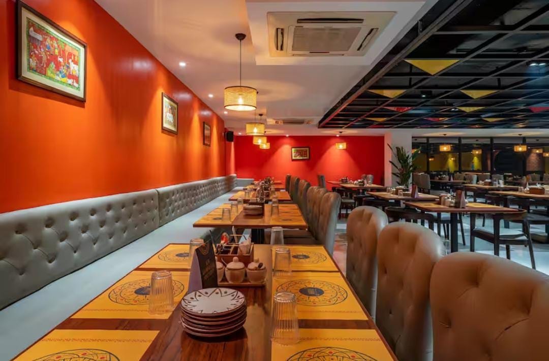 Naatu Kitchen And Bar — warm dining interior with wood and woven chairs