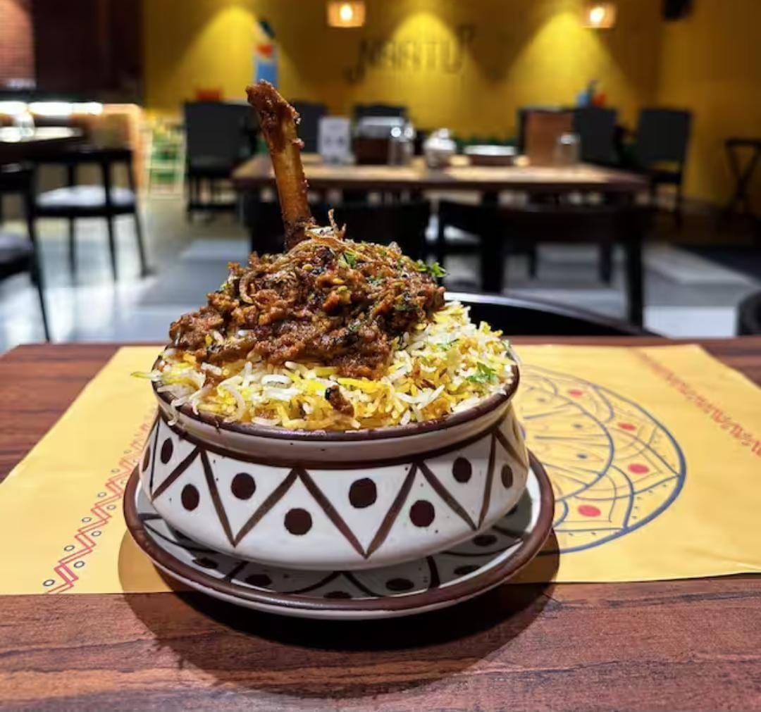 Naatu Kitchen And Bar dining — warm wood tables and earthy decor
